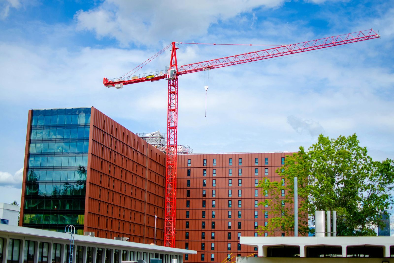 Ein roter Baukran vor einem Neubau
